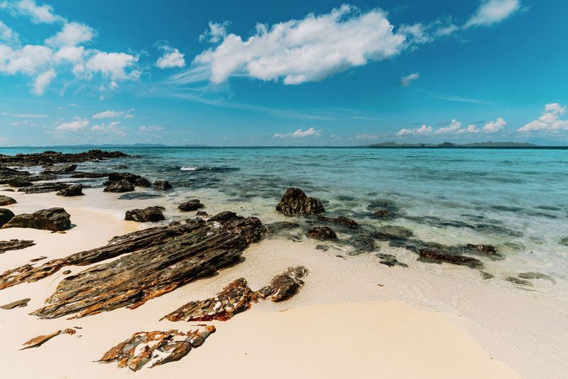 Rocks on a white sand beach with turquoise water in Ao Nang