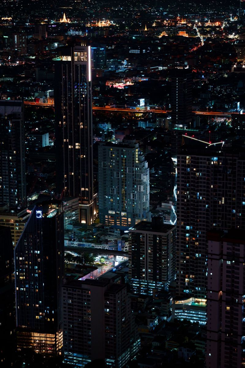 Bangkok's skyscrapers lit up at night above a busy road