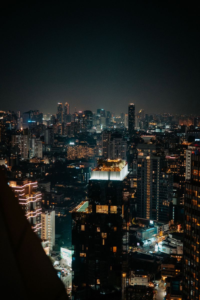 A city skyline lit up at night with towers and busy streets