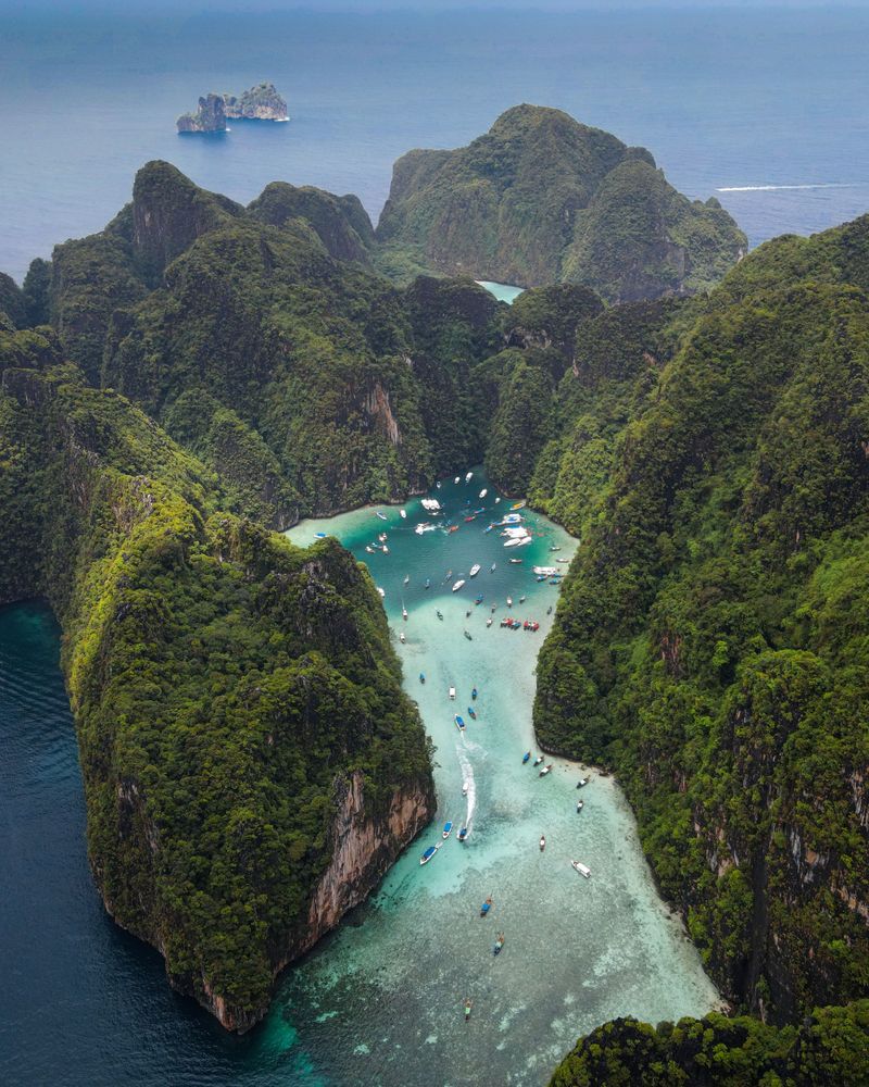 Jungle-covered limestone islands around a narrow turquoise inlet, seen from above