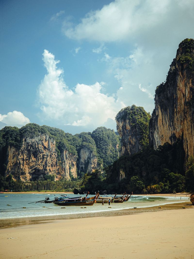 A beach below towering limestone cliffs in Krabi