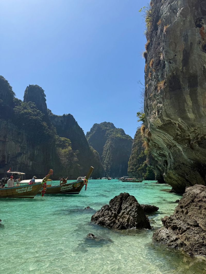 Turquoise water and rocks below limestone cliffs on Phi Phi