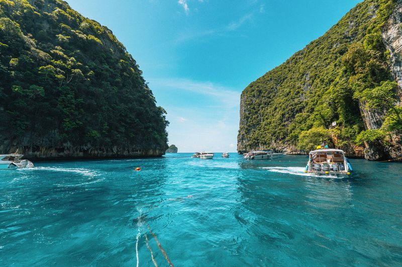 Clear water and green cliffs around a small beach in Krabi
