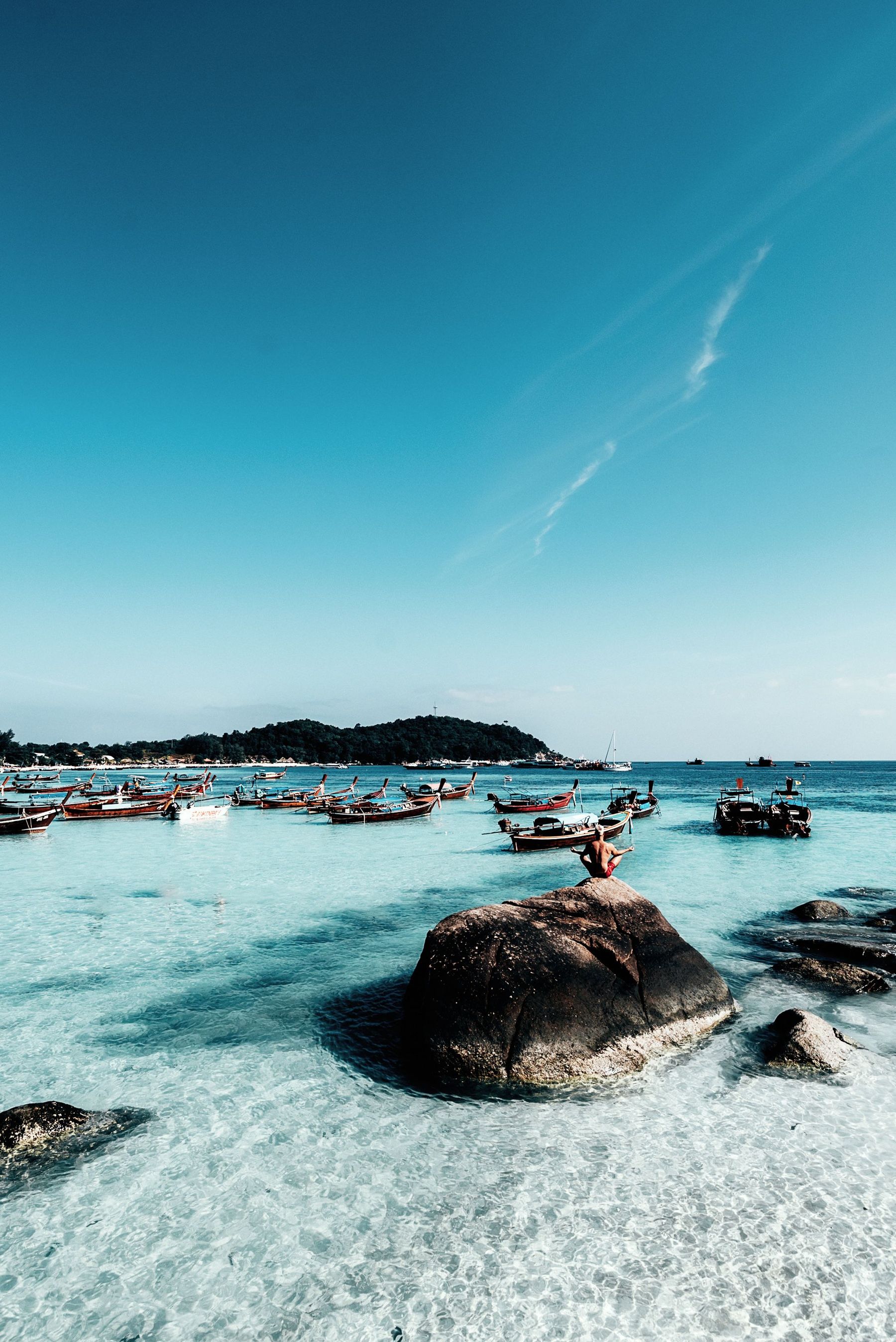 Clear turquoise water over rocks and sand on Koh Lipe