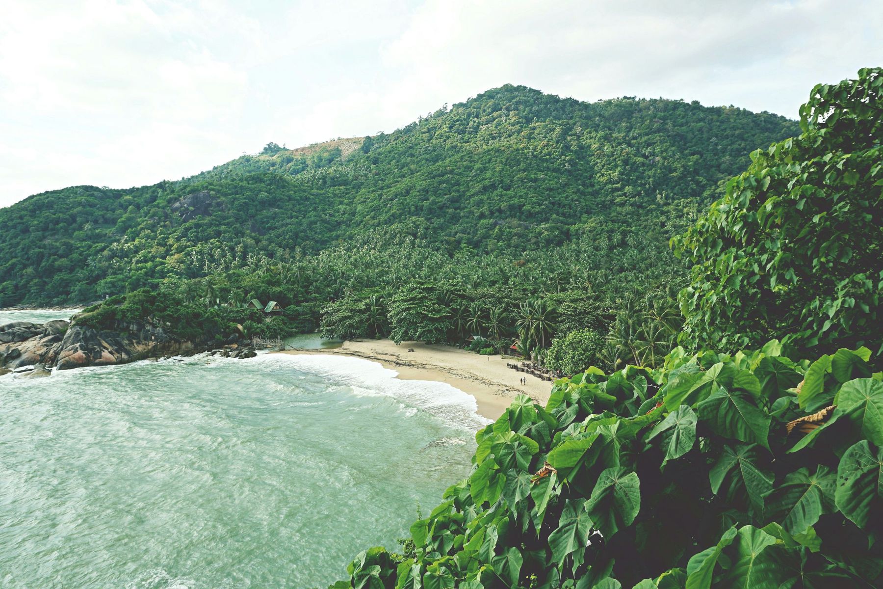 A beach between green hills on Koh Phangan