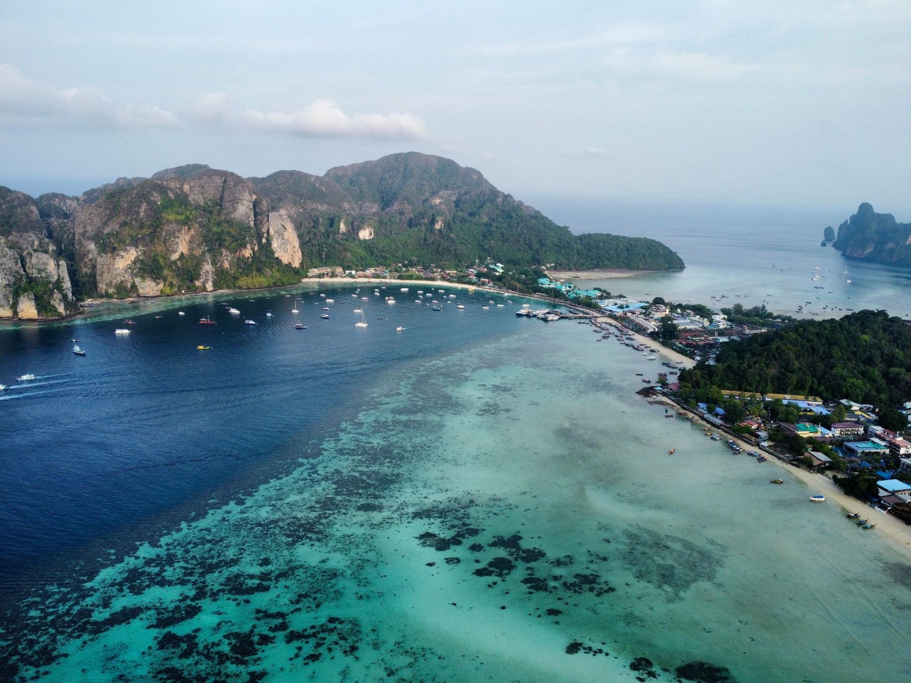 Aerial view of the Phi Phi coast with turquoise shallows and green hills