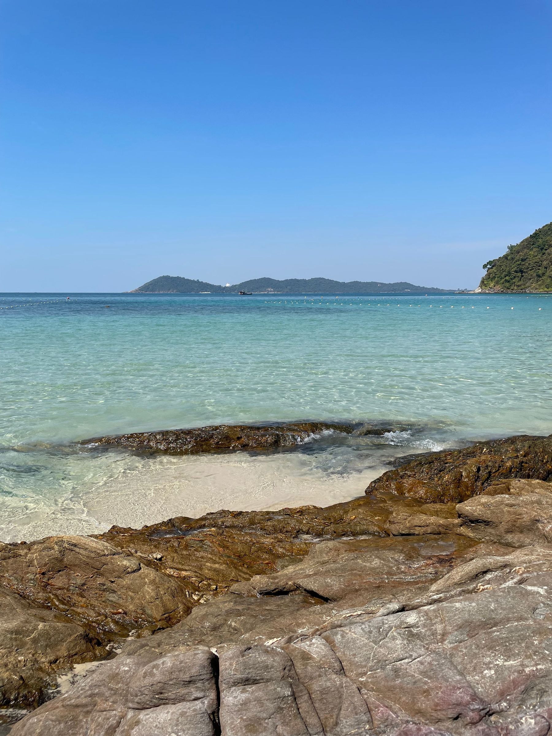 A beach and rocky shore on the Rayong coast, where Koh Samet lies